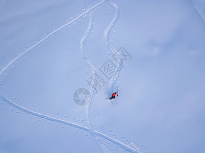 登山者在雪覆盖的偏远地区与旅游滑雪一起向上远足的鸟瞰图野图片