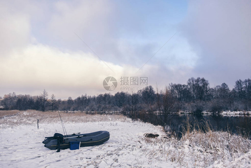 冬季河流岸边的充气渔船图片