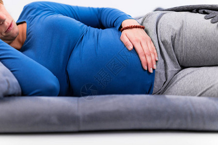 怀孕的疲惫妇女在家沙发上肚子有图片
