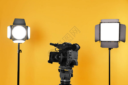 黄色背景的专业摄像专业录像摄机和照明图片