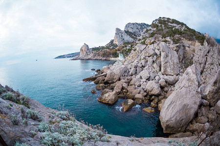 岩石海岸在冬天阴的海绿松石海水海洋岸上的图片