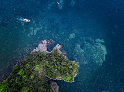 陡峭的悬崖和摩托艇的鸟瞰图亚得里亚海的锯齿状海岸悬崖俯瞰透明的大海野生自然和地中海背景图片