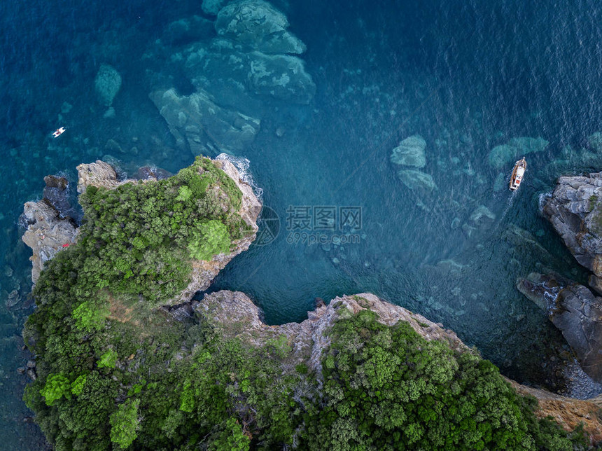 陡峭的悬崖和摩托艇的鸟瞰图亚得里亚海的锯齿状海岸悬崖俯瞰透明的大海野生自然和地中海图片