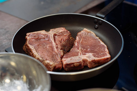 生鲜大理石牛肉放在烤盘上准备烹饪烹调牛排的人厨房里图片