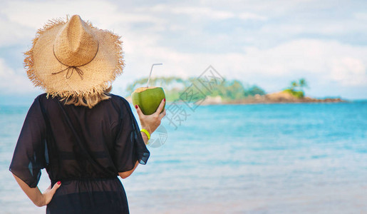海滩上的女孩喝椰子酒有选择图片