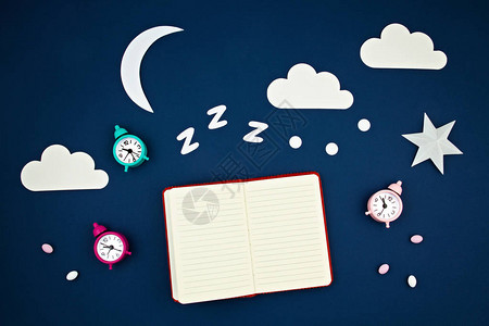 蓝色柔和时尚背景上的打鼾经典闹钟和睡眠跟踪器日记背景图片