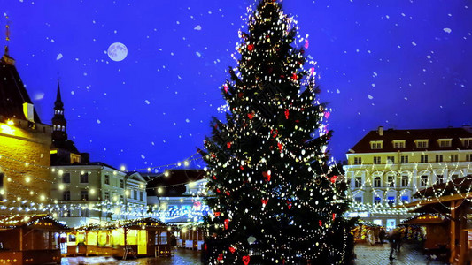 塔林中世纪街道城市老政厅广场假日餐厅窗外的夜景圣诞树人在街上的雨伞下行走模糊的夜灯生活方式城市旅行到欧背景图片