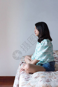 亚洲美女短牛仔裤独自坐在卧室的床上图片