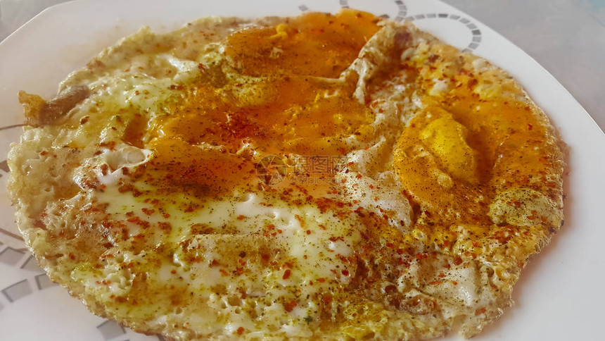 白盘上用油煮熟的鸡蛋图片