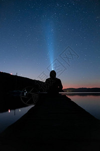 男人用手电筒凝视夜空图片