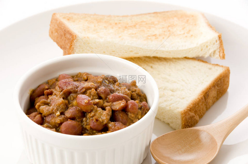 Chiliconcarneincocotte和盘子上的烤面包图片