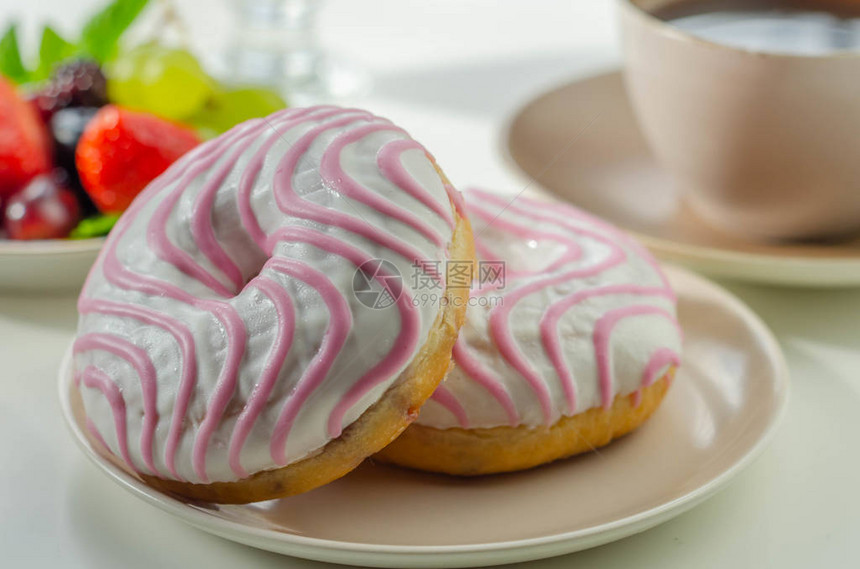 覆盆子味甜圈上面有白色和粉红色的糖图片