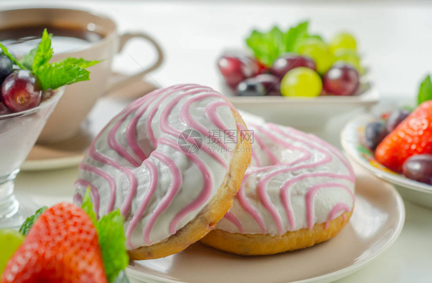 覆盆子味甜圈上面有白色和粉红色的糖图片