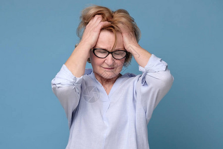 戴眼镜的年长妇女因偏头痛或头痛图片