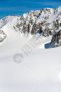 爬行者穿越大雪覆盖高山的冰川徒步图片