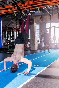 运动员在健身房里倒立在他的手上行走男人在他的手上做俯卧撑交叉配合训练锻炼生活方式的概背景图片