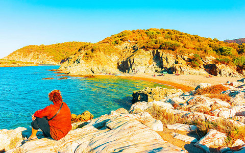意大利南部撒丁岛Cagliari省地中海Chia海滩和蓝色水域的妇女和景观风化与自然混合媒体背景图片