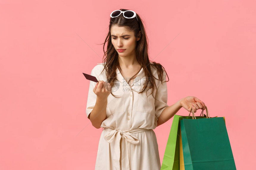 困惑和困惑的女购物狂拿着购物袋图片