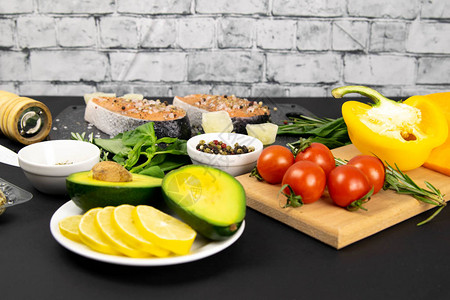 一组健康平衡的超级食品浅地柠檬和鳄梨新鲜鲑鱼蔬菜谷物和黑底坚果顶图片