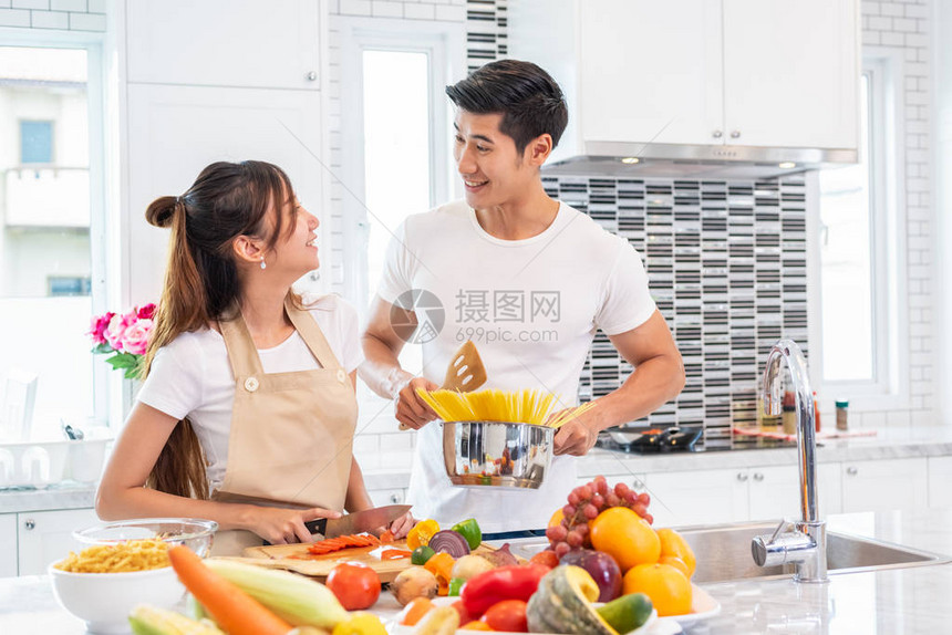 快乐的亚洲年轻已婚夫妇准备在厨房里做意大利肉酱男朋友和女朋友一起做饭人们的生活方式和浪漫关系概念图片