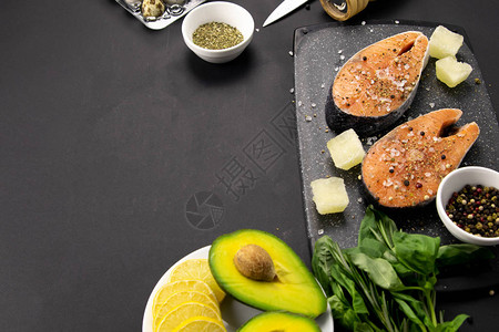 一套健康平衡的超级食品新鲜鲑鱼蔬菜黑色背景的谷类食品图片