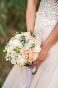 美丽的婚礼花束在新娘手中玫瑰色粉色和桃色时尚现代的婚礼鲜花户外穿图片