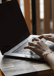 女人的手在笔记本电脑键盘上打字图片