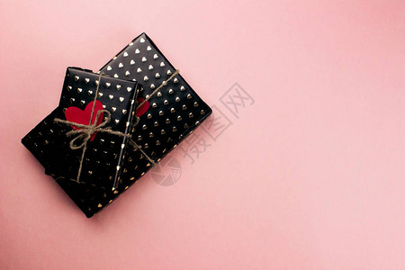 用心纸包裹的礼品盒平铺在粉红色的背景上图片