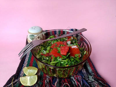 营养丰富的豆瓣菜沙拉配粉红色背景的番茄素食图片