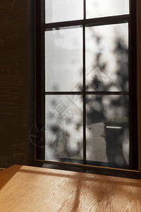 斑驳的光透过窗户落在木桌上图片