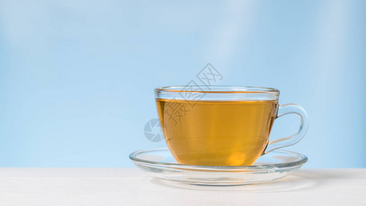 一杯中茶和一盘白桌上的酱汁图片