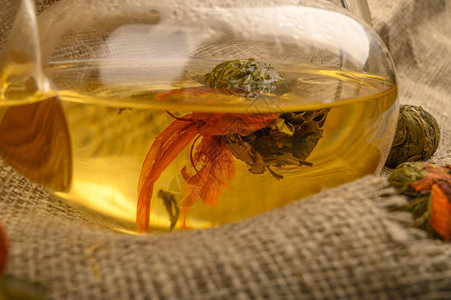 鲜花茶泡在玻璃茶壶和花生茶球中背景是粗图片