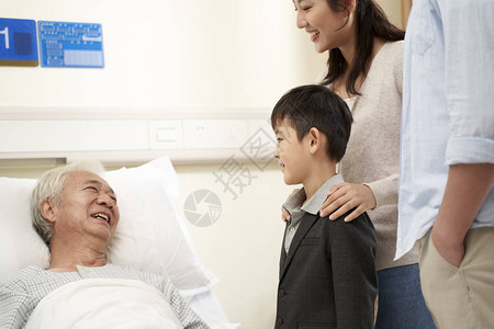父母亲和儿子在医院探望祖父的亚洲图片