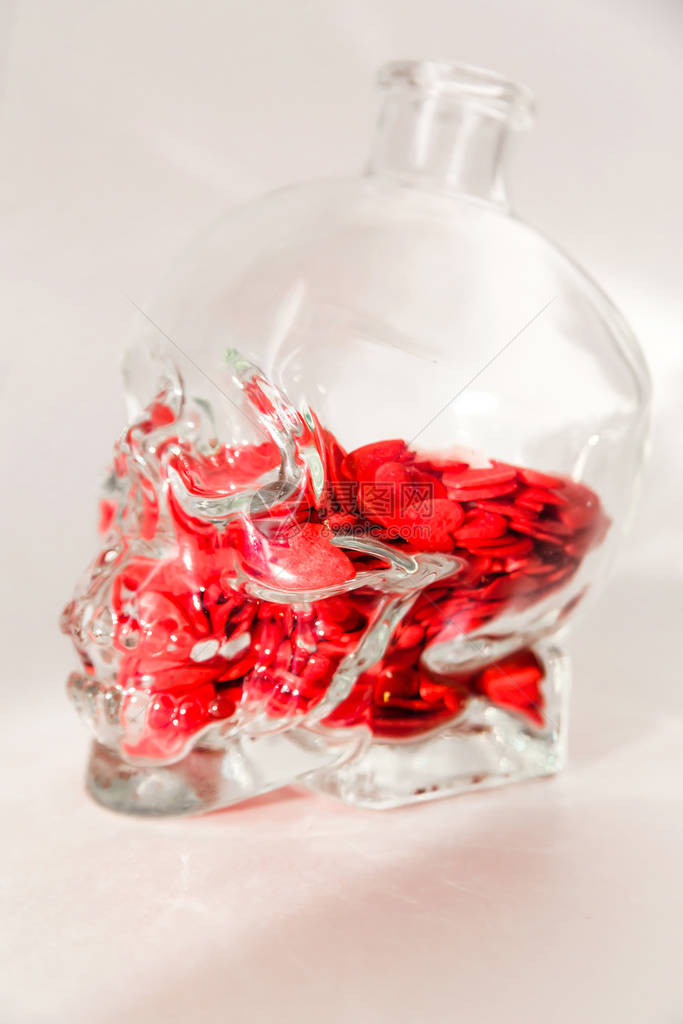 一个人头骨形状的玻璃瓶装满了红心图片