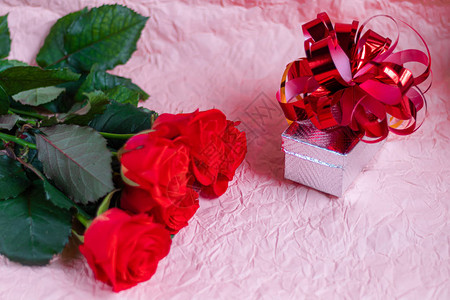 粉红色背景的母亲节妇女节情人节或生日玫瑰和盒子包装祝贺横幅图片