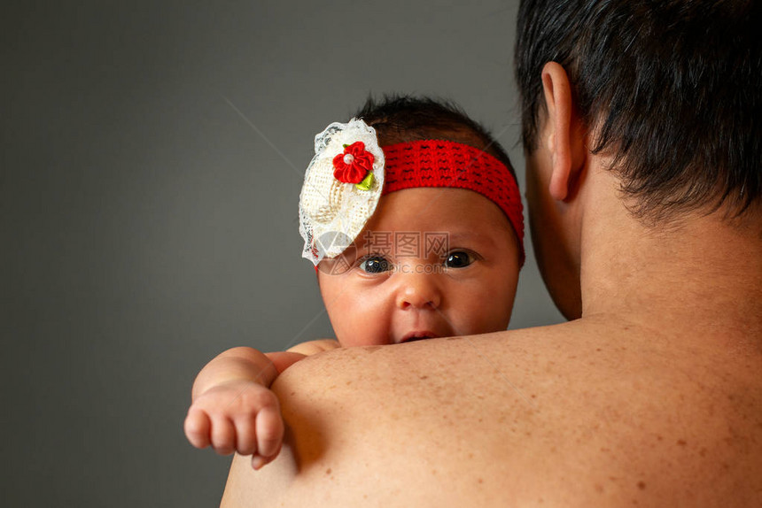 显示父亲将新生女儿抱在肩膀上的照片照图片