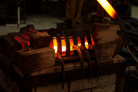 铁匠在工业炉中加热金属棒图片