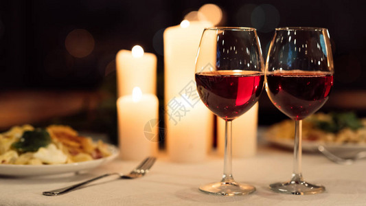 浪漫的约会晚宴背景两杯红酒在饭馆配有食物和烧烤蜡烛的盛图片