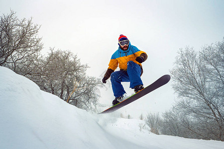 这家伙在滑雪他从雪山跳下来在新鲜的雪上滑图片