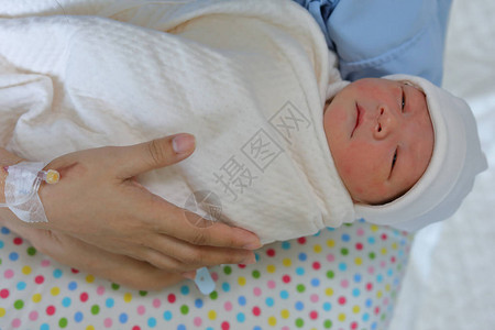 妇女母亲在医院分娩新生儿后抱着一个图片