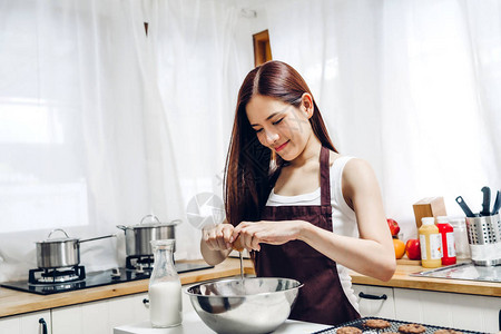 微笑的女人站在炉子和锅边做饭准备在家厨图片