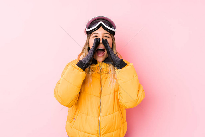 身穿粉红背景滑雪衣的年轻caucasian女在图片