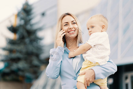 穿着蓝色西装的成功女商人带着婴儿成功的母亲带着婴儿图片