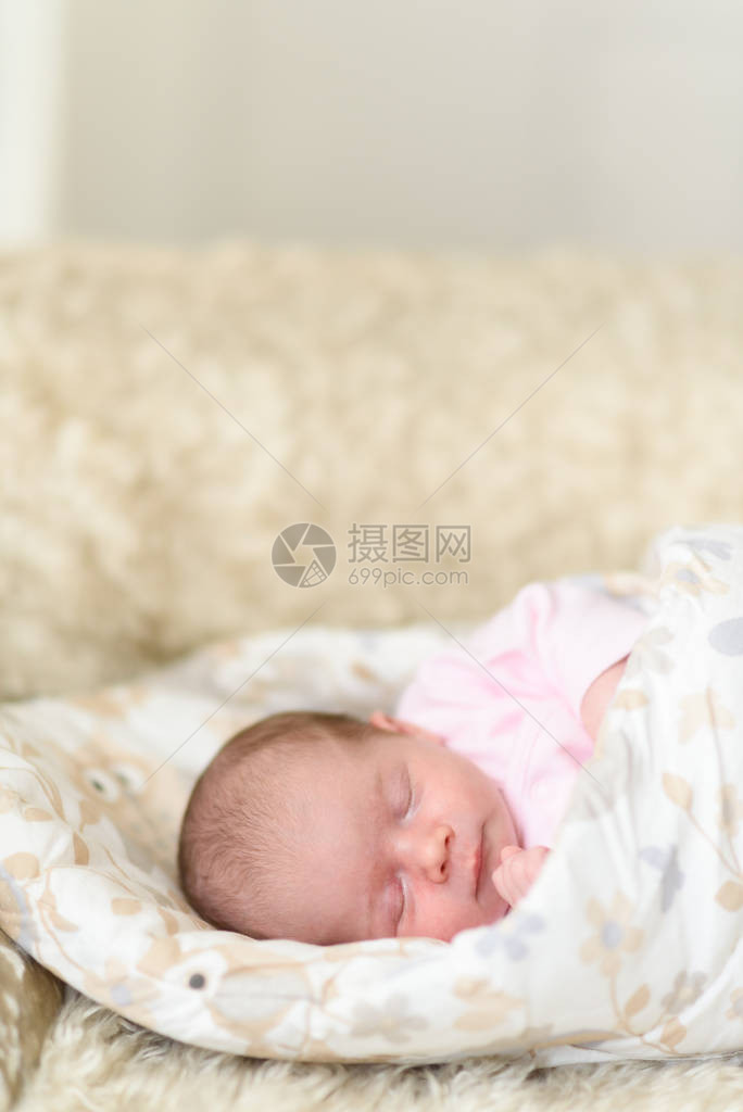 睡着的新生婴儿可爱的小女孩一周大在家可爱的躺在一边盖着毯子没有润饰图片