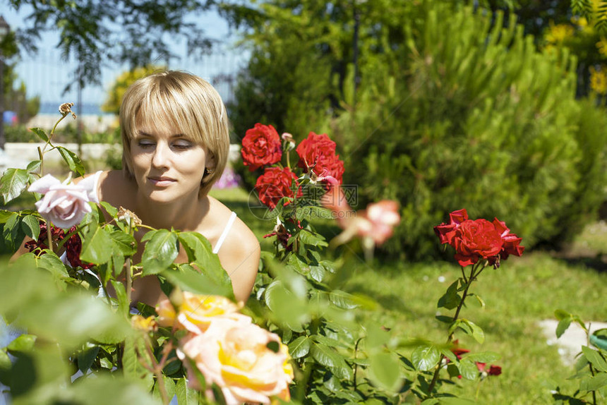 绿色玫瑰花园的年轻美女快乐笑生活方式图片