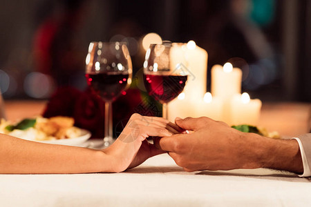 浪漫与爱情美酒蜡烛和玫瑰晚间浪漫约会在服务餐厅桌旁拉图片