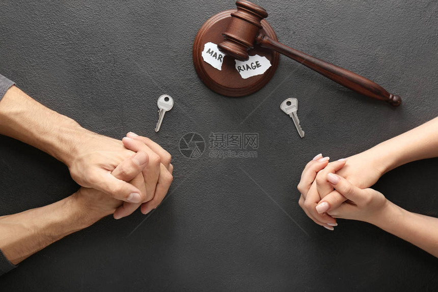 夫妻手握钥匙法官在黑暗背景图片