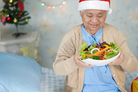 亚洲老年或老年妇人患者戴着圣诞老人助手帽图片