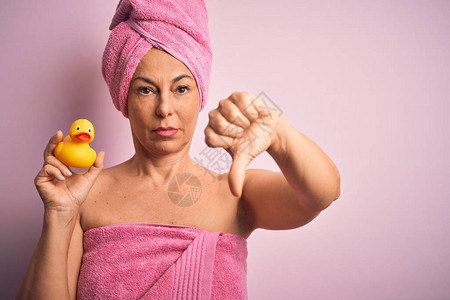 中年妇女穿着从美容护理处得到的粉红浴巾图片