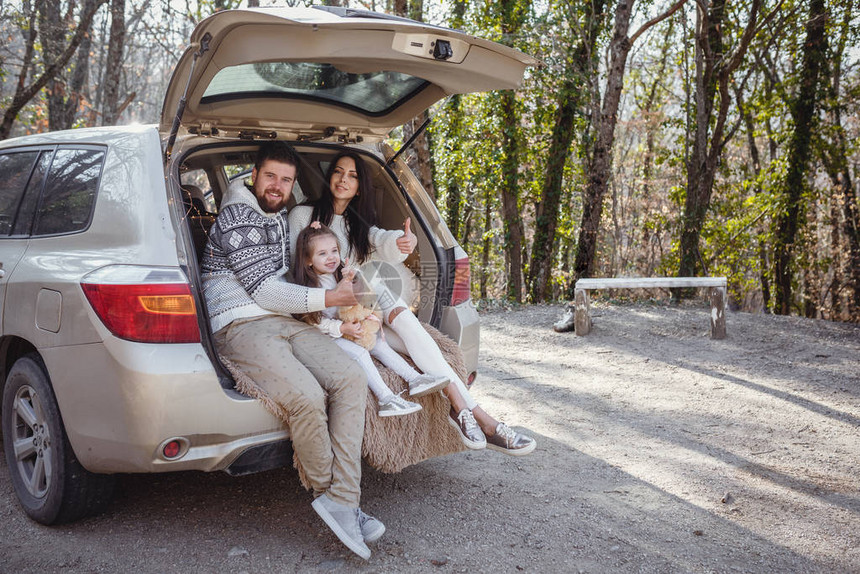 一个关于幸福家庭之旅的系列年轻快乐的父母和他们的小女儿在森林里享图片
